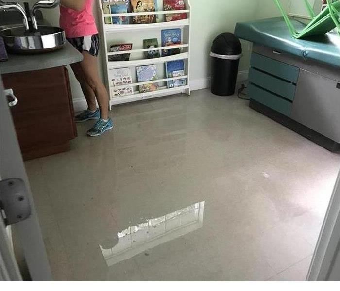 Picture of person standing in water on an exam room floor.