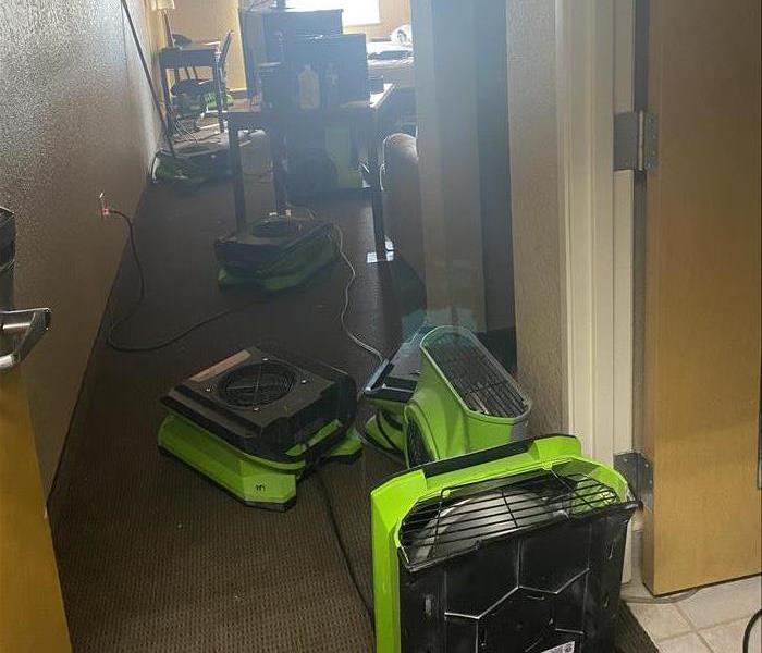Hotel room with green SERVPRO drying equipment